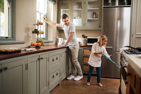 dad and child cleaning kitchen
